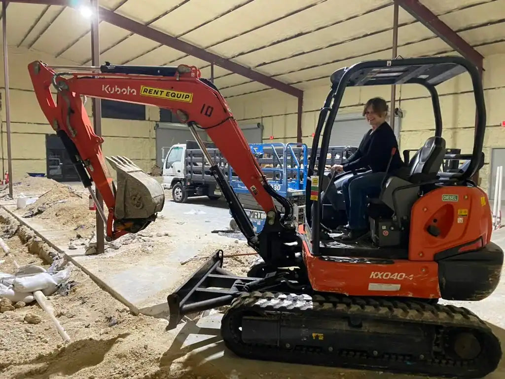 Kirsten Maitland, Rebel Cheese CEO, on a backhoe.