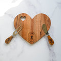 heart-shaped woodedn cheese board with cheese knife and fork