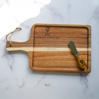 wooden cheese board and cheese knife on a white marble background