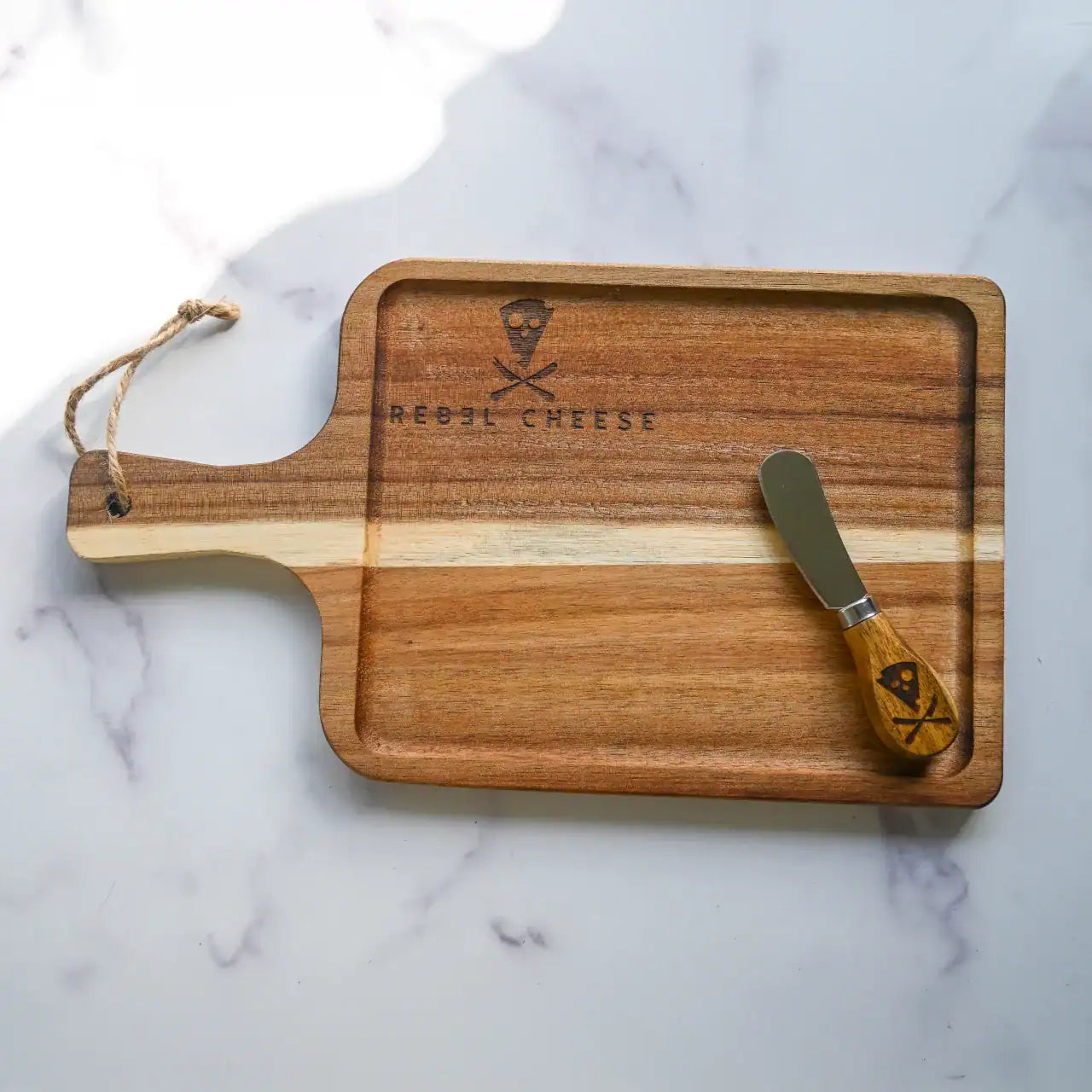 wooden cheese board and cheese knife on a white marble background