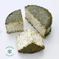 Slices of dairy-free Lemon Dill Fromage on a white marble background