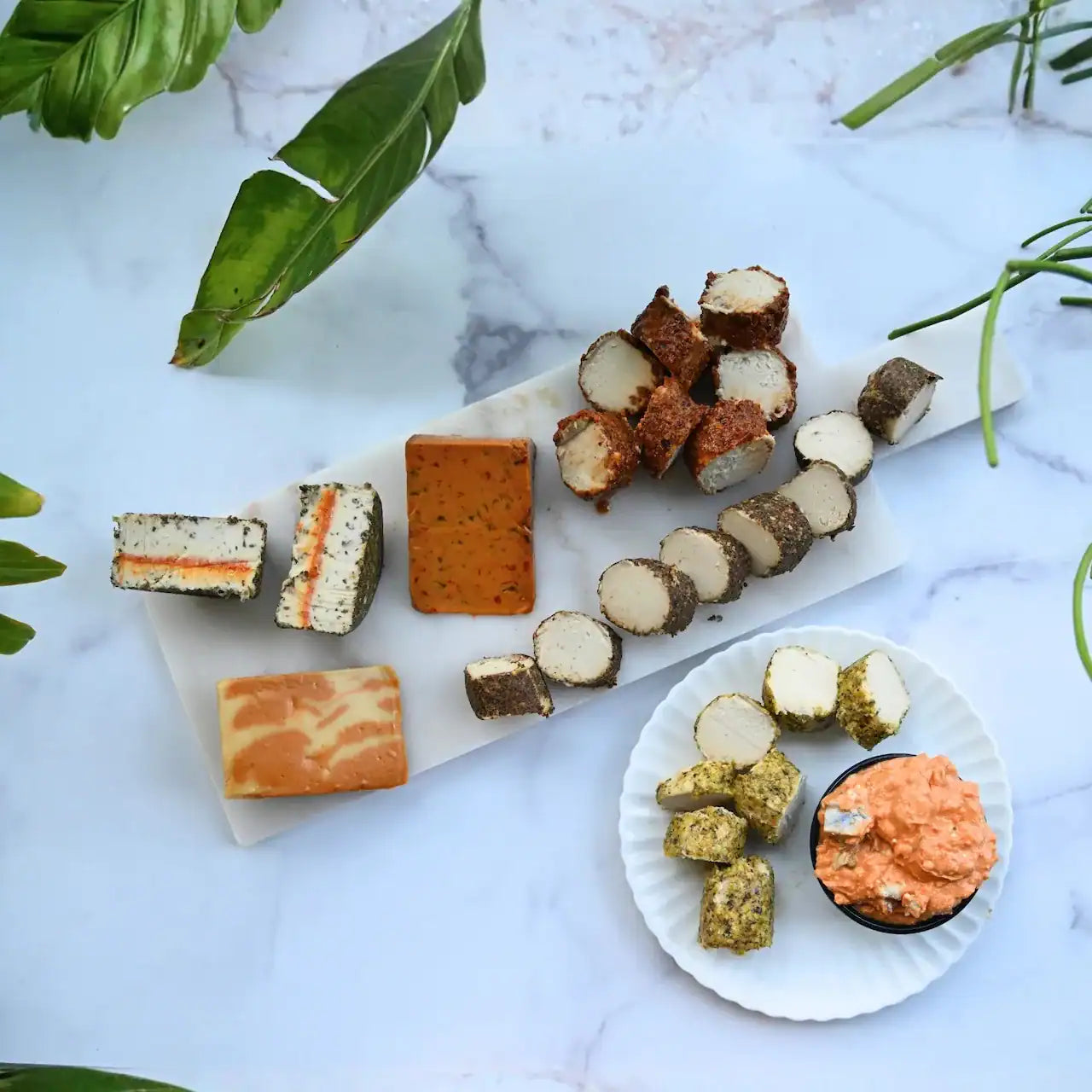 assorted dairy-free cheeses on a cheese board and plate from Rebel Cheese