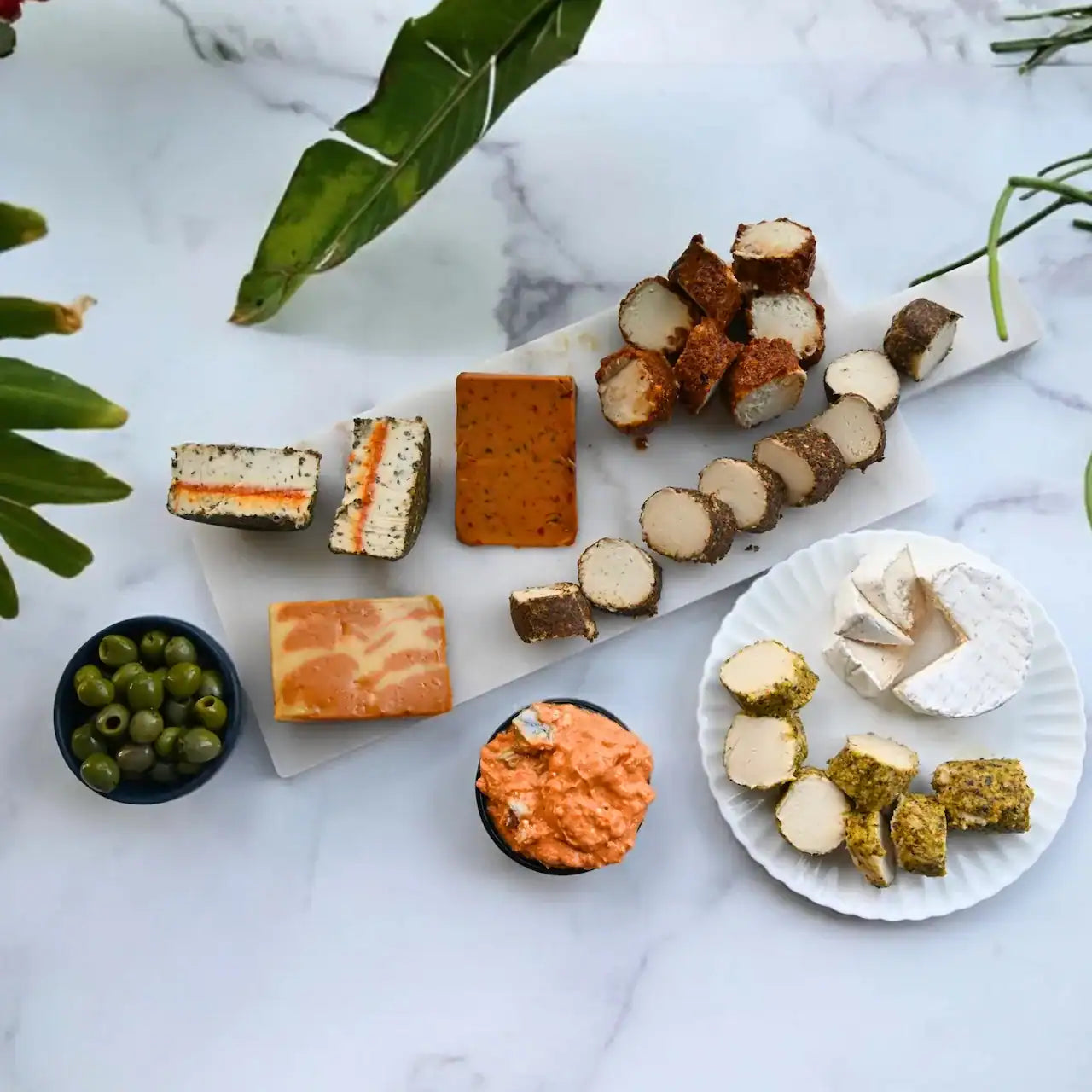 assorted dairy-free cheeses on a cheese board and plate from Rebel Cheese