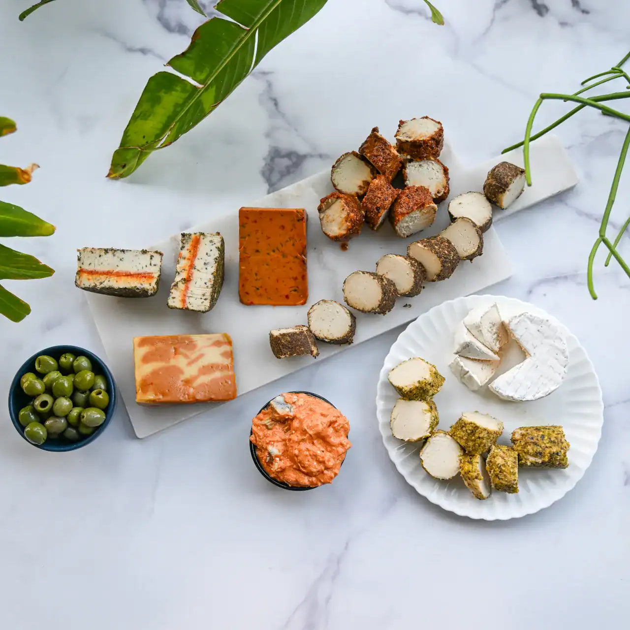 assorted dairy-free cheeses on a cheese board and plate from Rebel Cheese