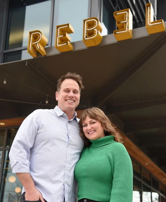Kirsten and Fred standing in front of Rebel Cheese sign