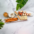 assorted dairy-free cheeses sliced on a white marble cheese board and a small mason jar of Pimento Cheese from Rebel Cheese.