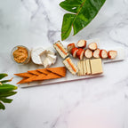 assorted dairy-free cheeses sliced on a white marble cheese board and a small mason jar of Pimento Cheese from Rebel Cheese.