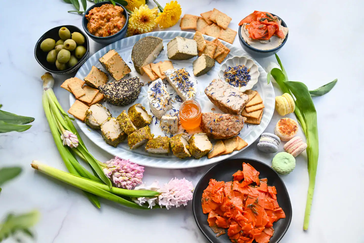 Assorted snacks and appetizers on a white plate with garnishes on a light background