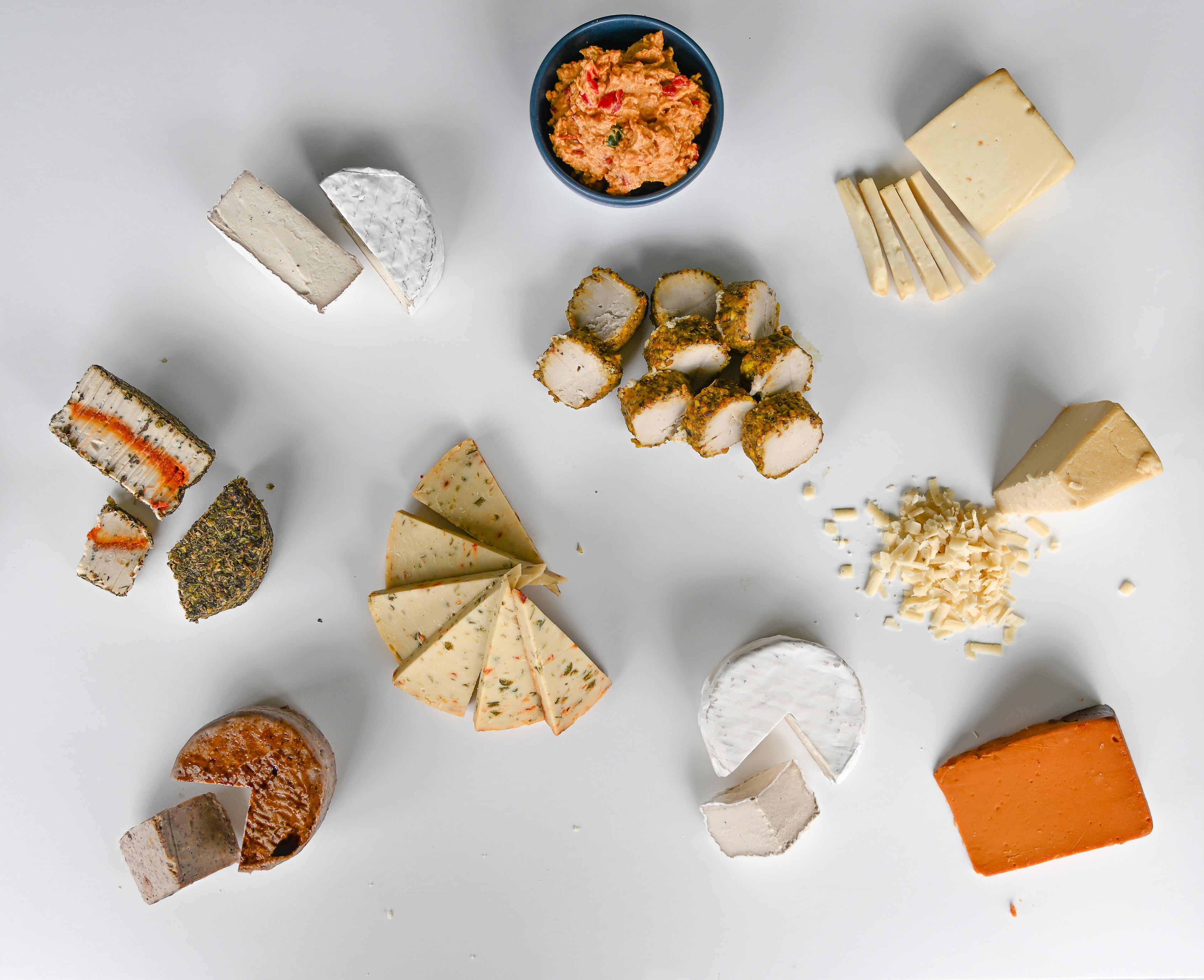 Assorted vegan cheeses on a white background