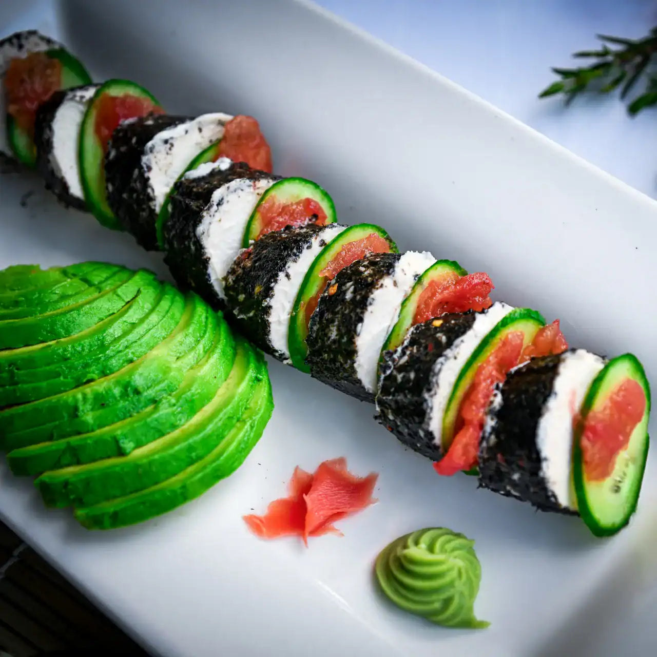 Rebel Roll plant-based sushi-inspired cheese styled on a board with pickled ginger, avocado, and wasabi.