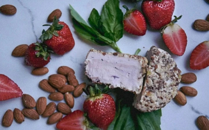 Strawberry Basil Fromage cut in half surrounded by strawberries.